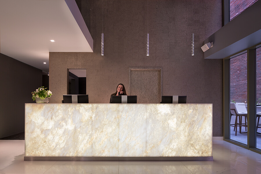 A woman is standing in front of a marble counter in a hotel near Chase Center.