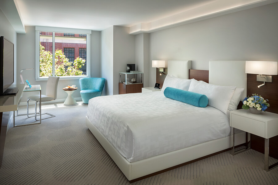 A south beach San Francisco hotel room near Oracle Park with a large bed and blue accents.