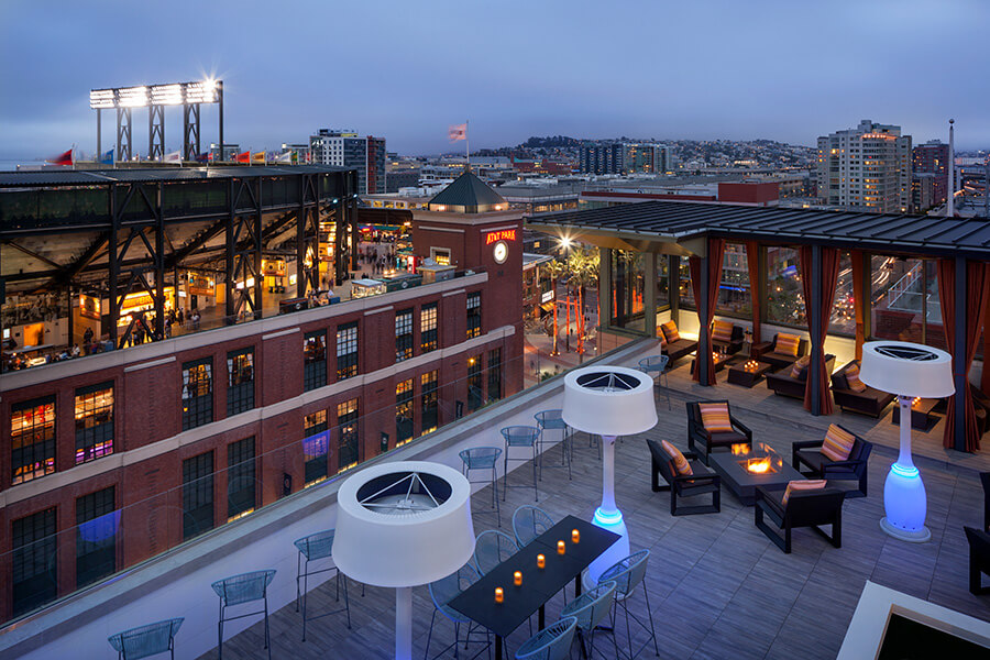A view of a city at night, with a boutique hotel near Oracle Park.