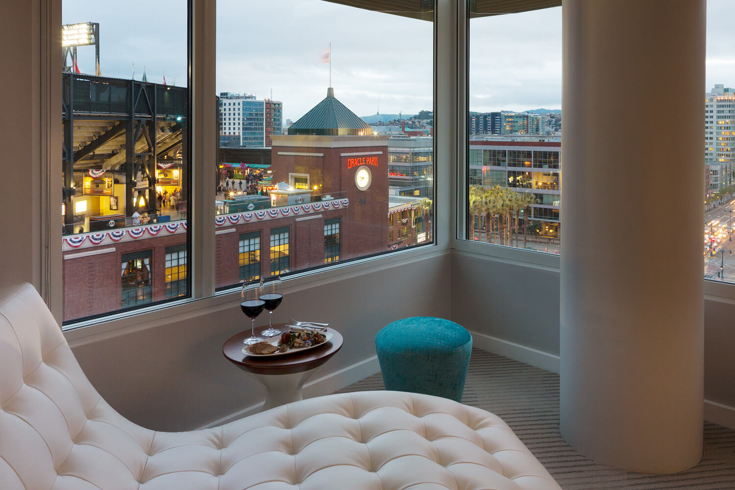 A white chair in a room with a view of a city, located in a hotel near Chase Center.